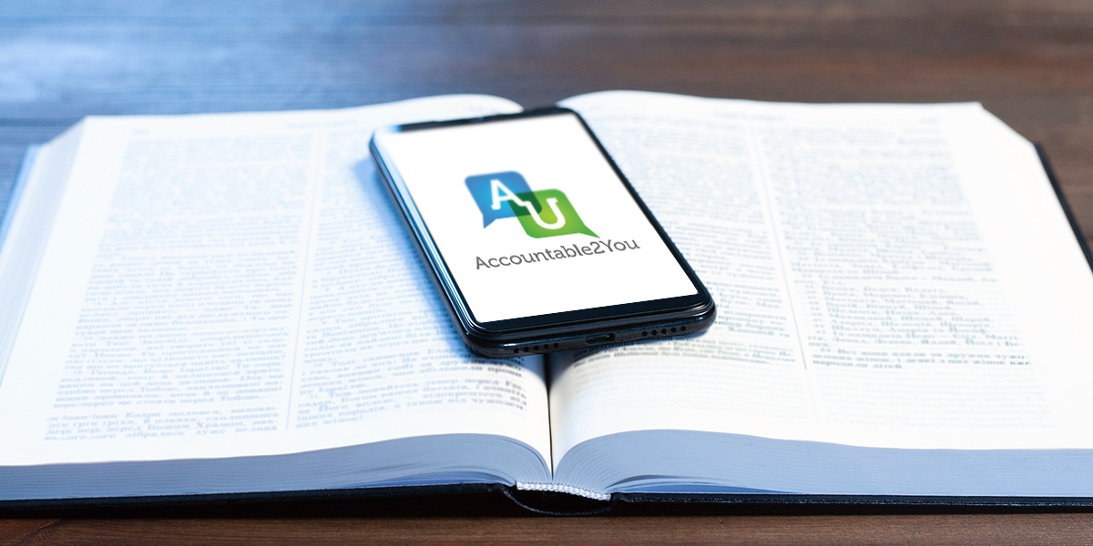 Phone on open Bible with Accountable2You accountability software